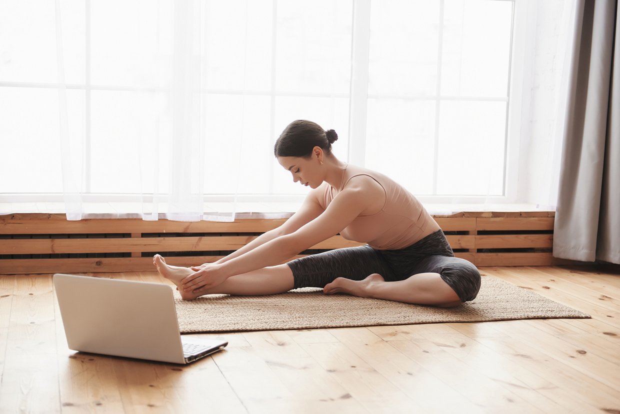 Young woman practicing yoga online